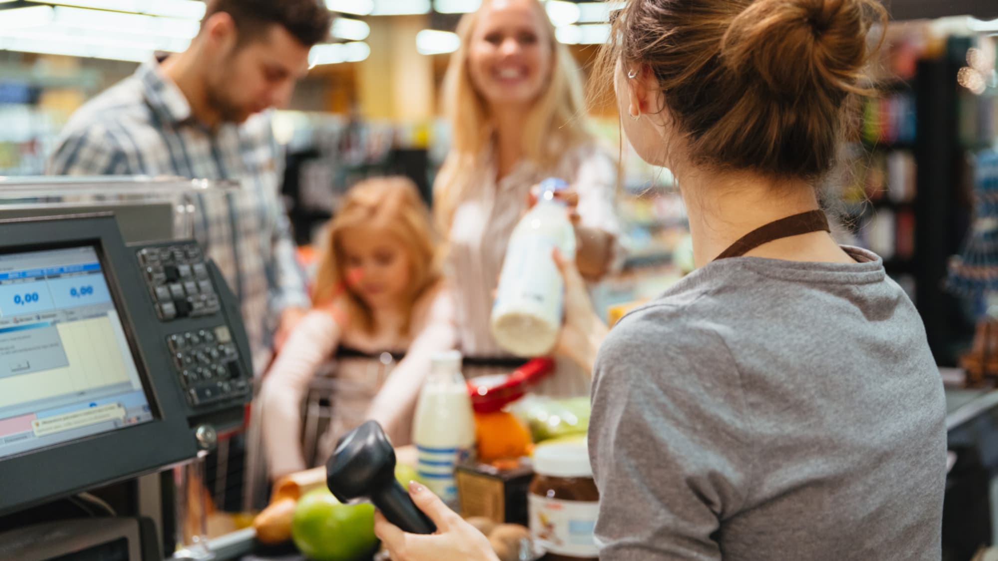 девушка продавец пробивает продукты