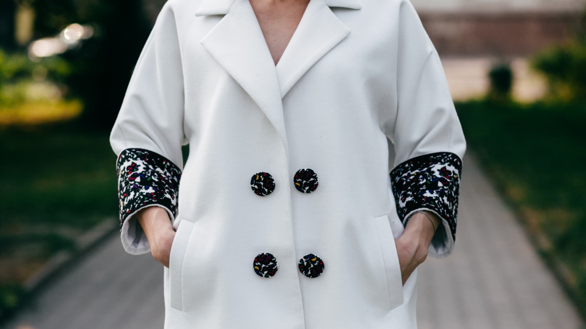 женщина в белом пальто с бархатной черной отделкой