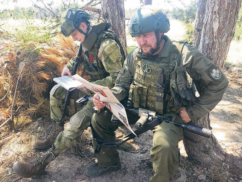 Казаки читают боевой листок о действиях Добровольческого штурмового корпуса