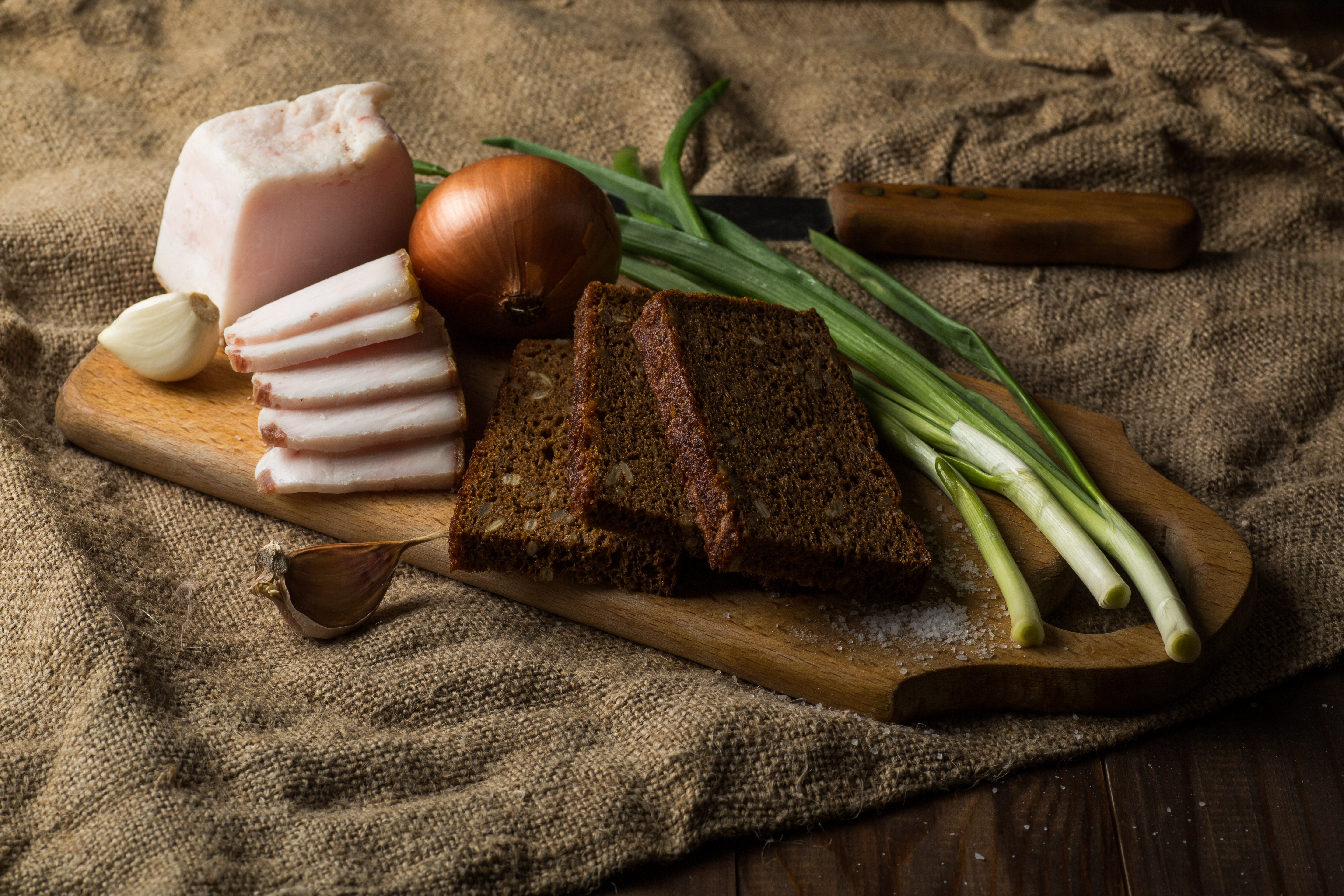 bacon, rye bread, pickles, onions on a black wooden table