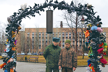 Заместитель начальника управления Народной милиции ДНР Эдуард Басурин показывает украинскому военнослужащему, перешедшему на сторону Донецкой Народной Республики, Анатолию Тараненко (справа) мемориал погибшим детям Донбасса «Аллея ангелов»